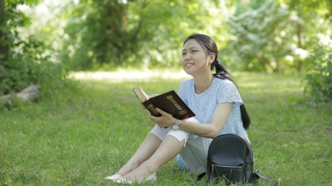 姊妹在草坪上看神話很開心